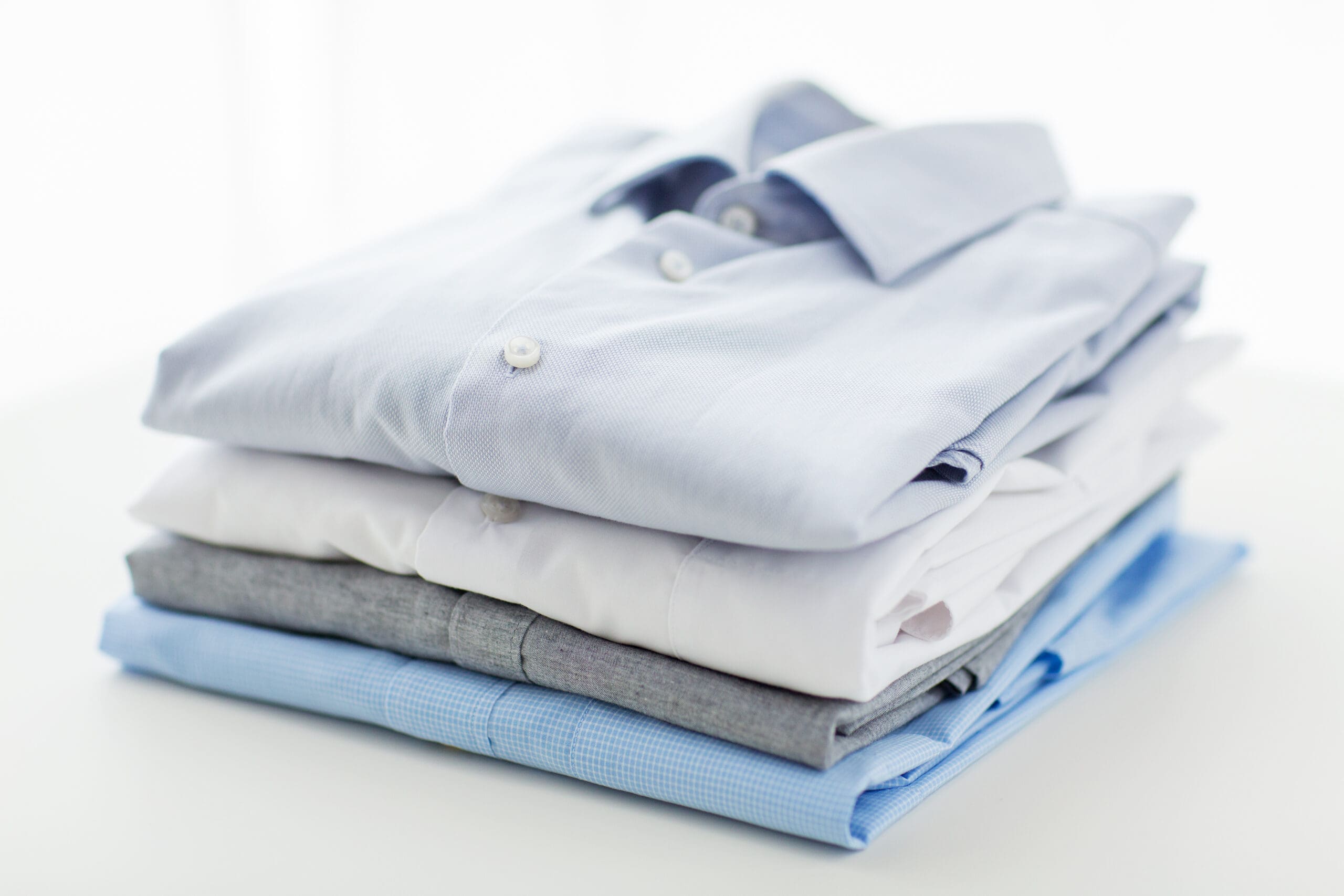 A neatly stacked pile of freshly laundered shirts.