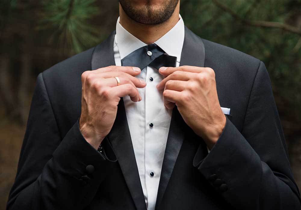 Several neatly pressed shirts hanging on hangers against a bright background.